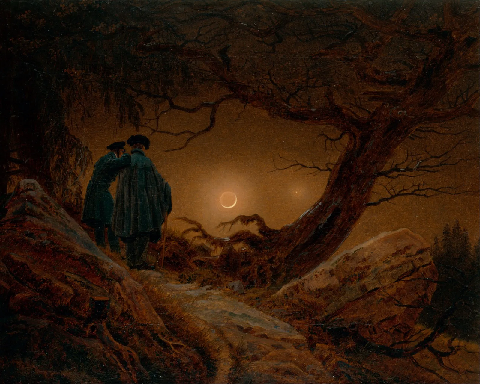 Two men in dark coats standing together on a rocky path under a twisted tree, looking at a crescent moon